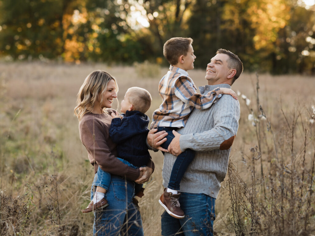 mom and dad holding two sons for family photos at the park Cleveland Gymnastics