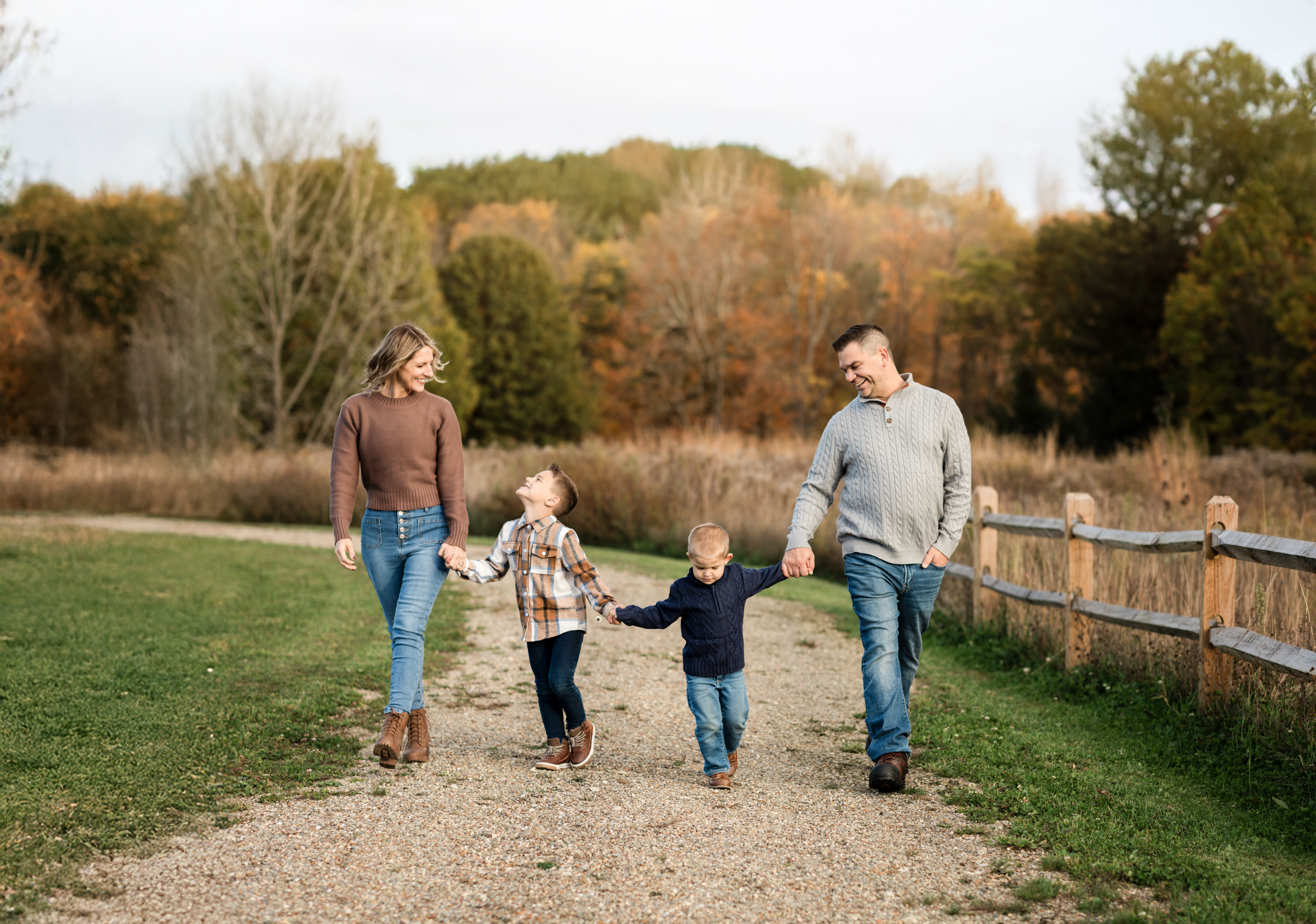 parents holding hands and walking in park with two sons Cleveland Gymnastics