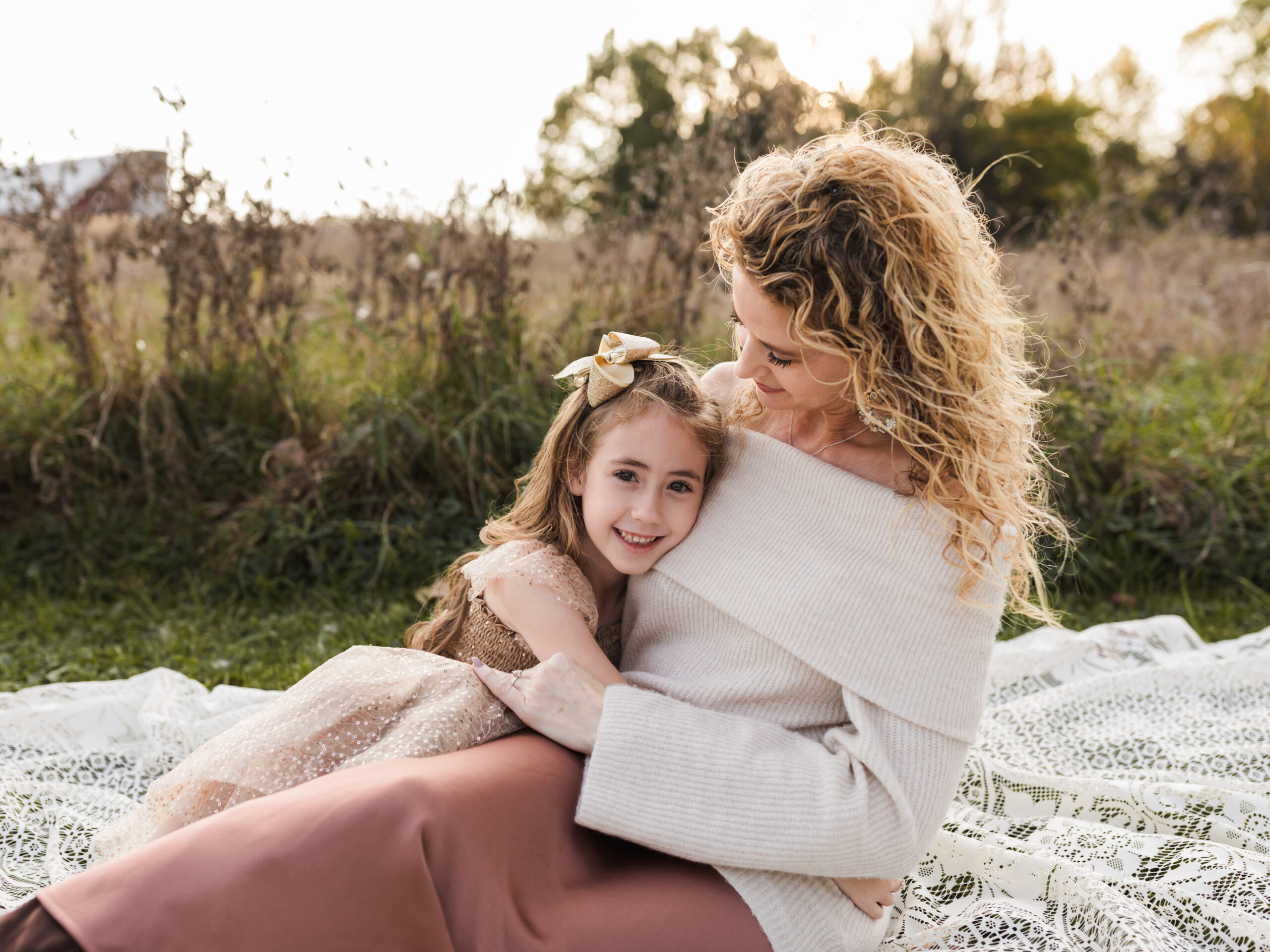 mom and daughter laying on white lace blanket for family photos Hiking Trails Near Cleveland
