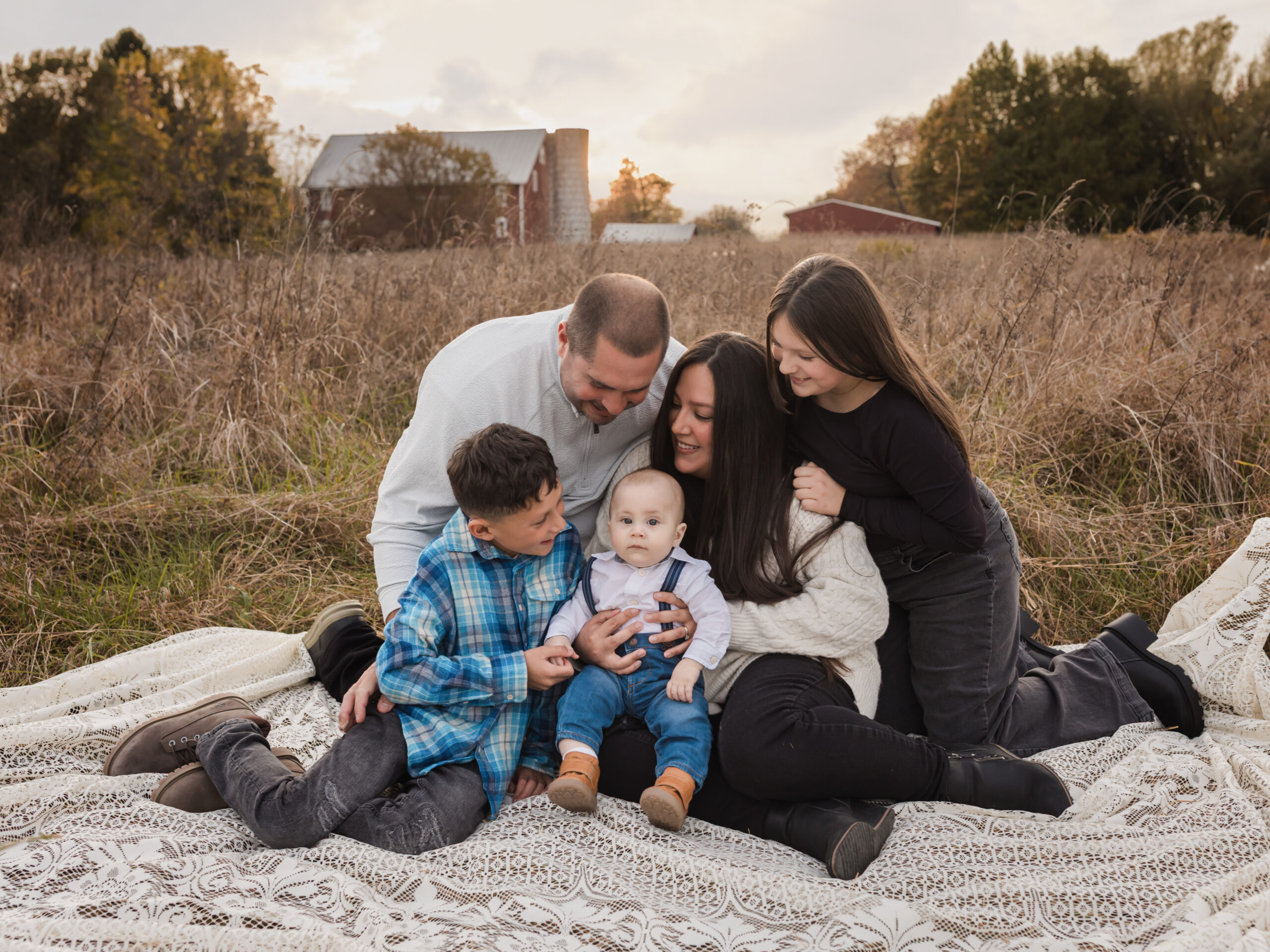 mom and dad sitting on lace blanket with three children for fall family photos Ice Skating Rinks in Cleveland Ohio