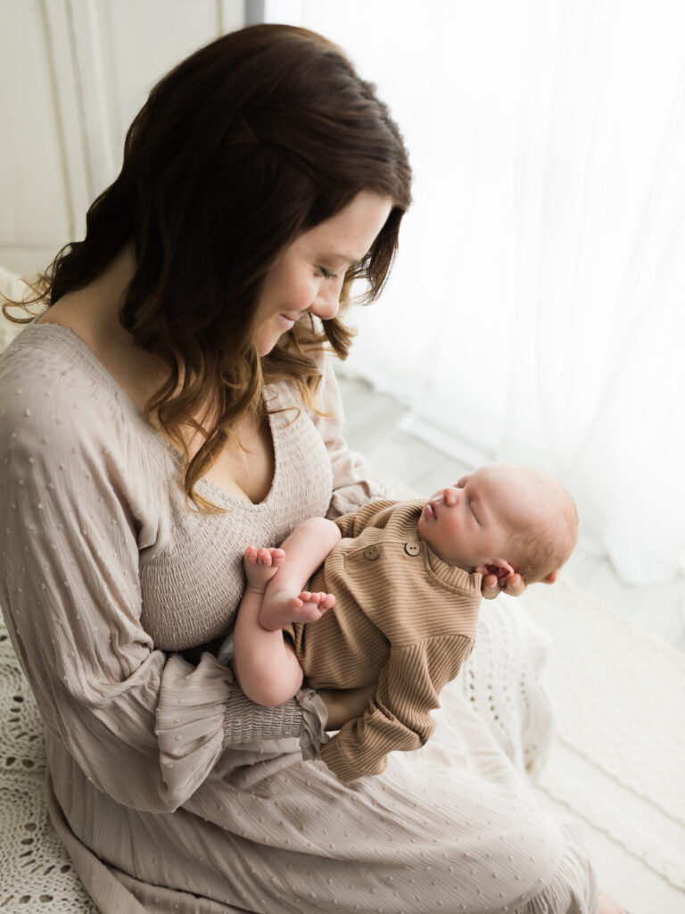 mom holding newborn baby boy for studio portraits