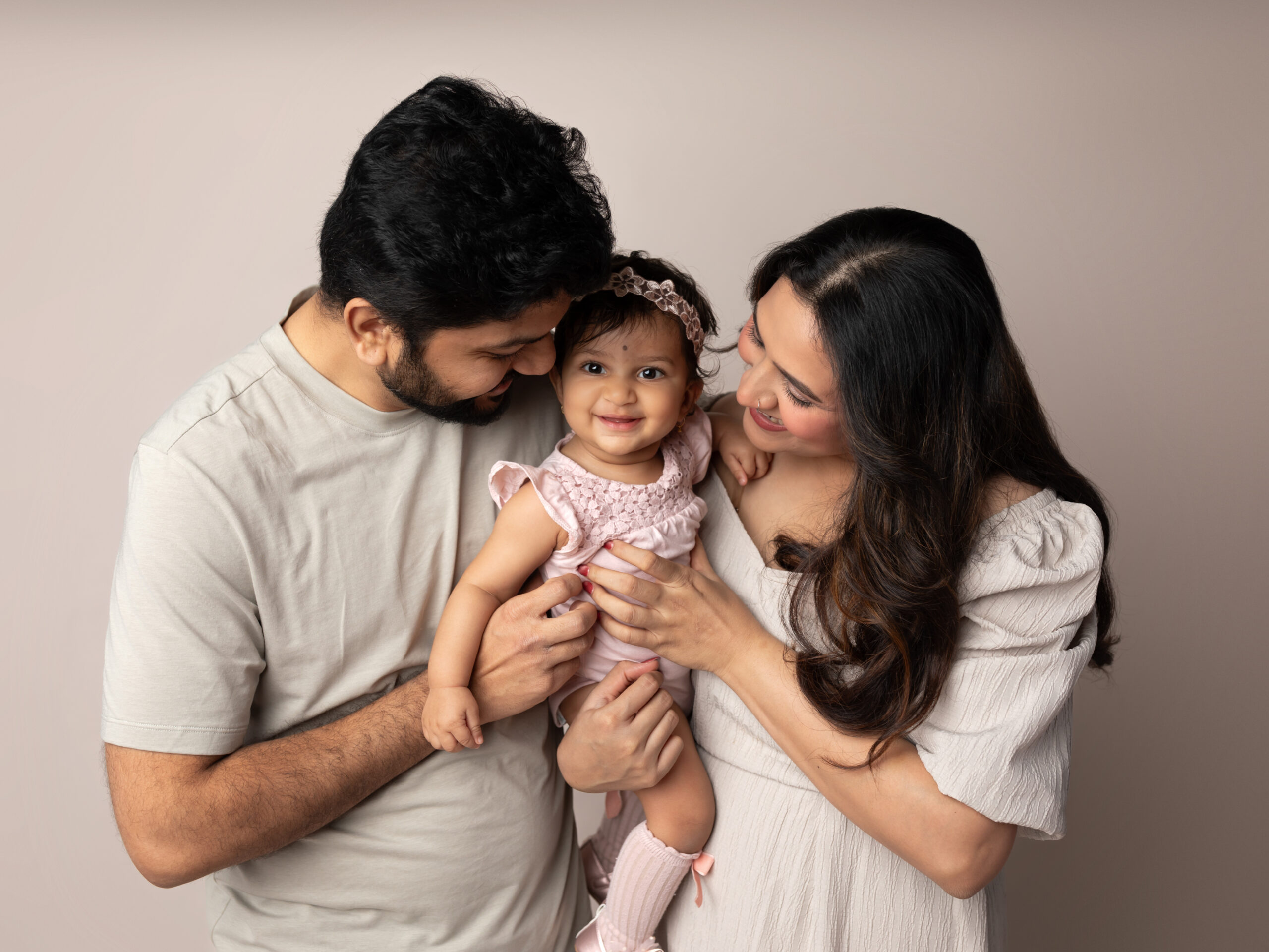 mom and dad holding one year old girl for studio family photos Preschools in Strongsville Ohio