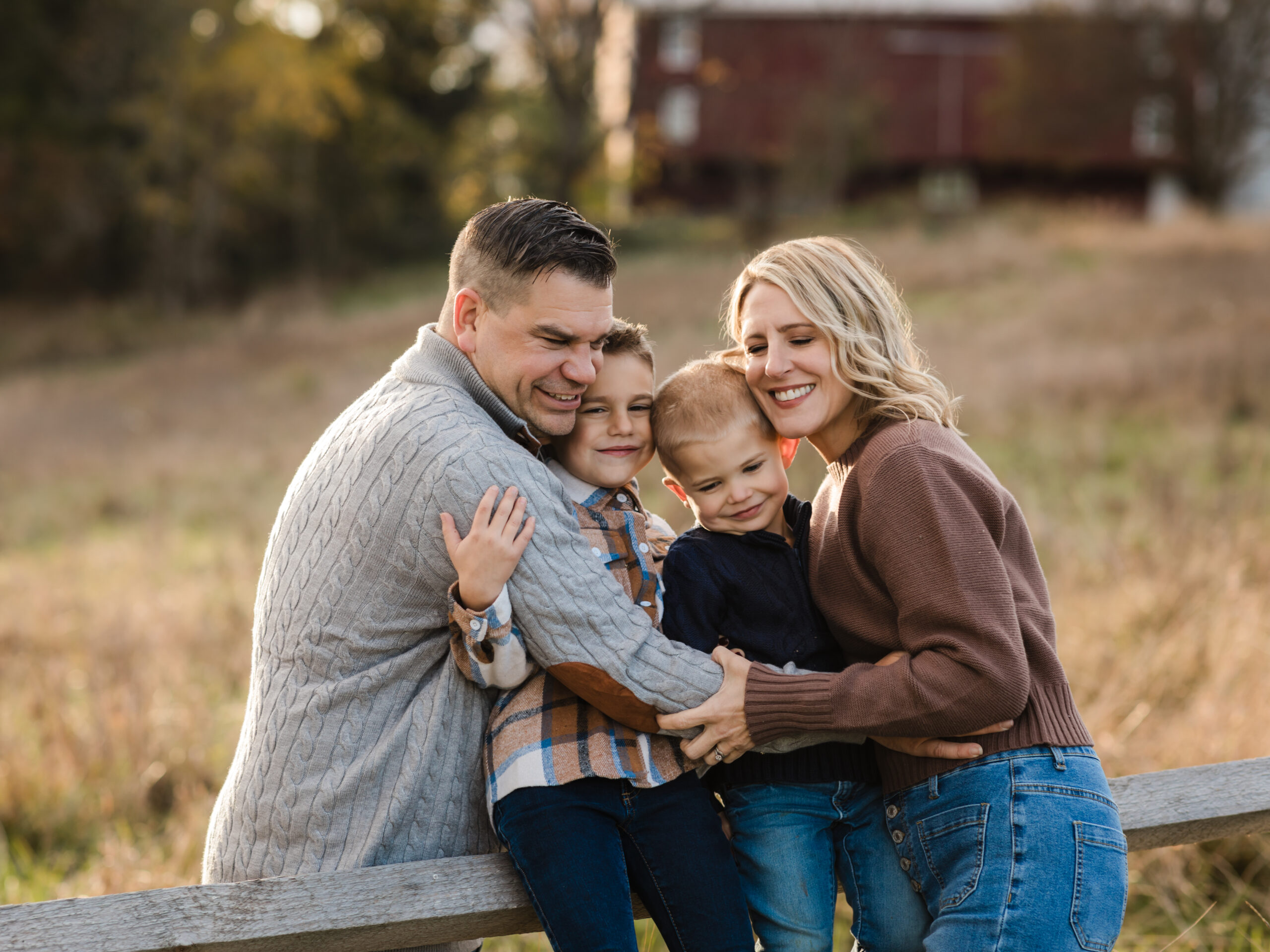 mom and dad hugging and laughing with two sons for fall family photos The Enrichment Center of Wishing Well