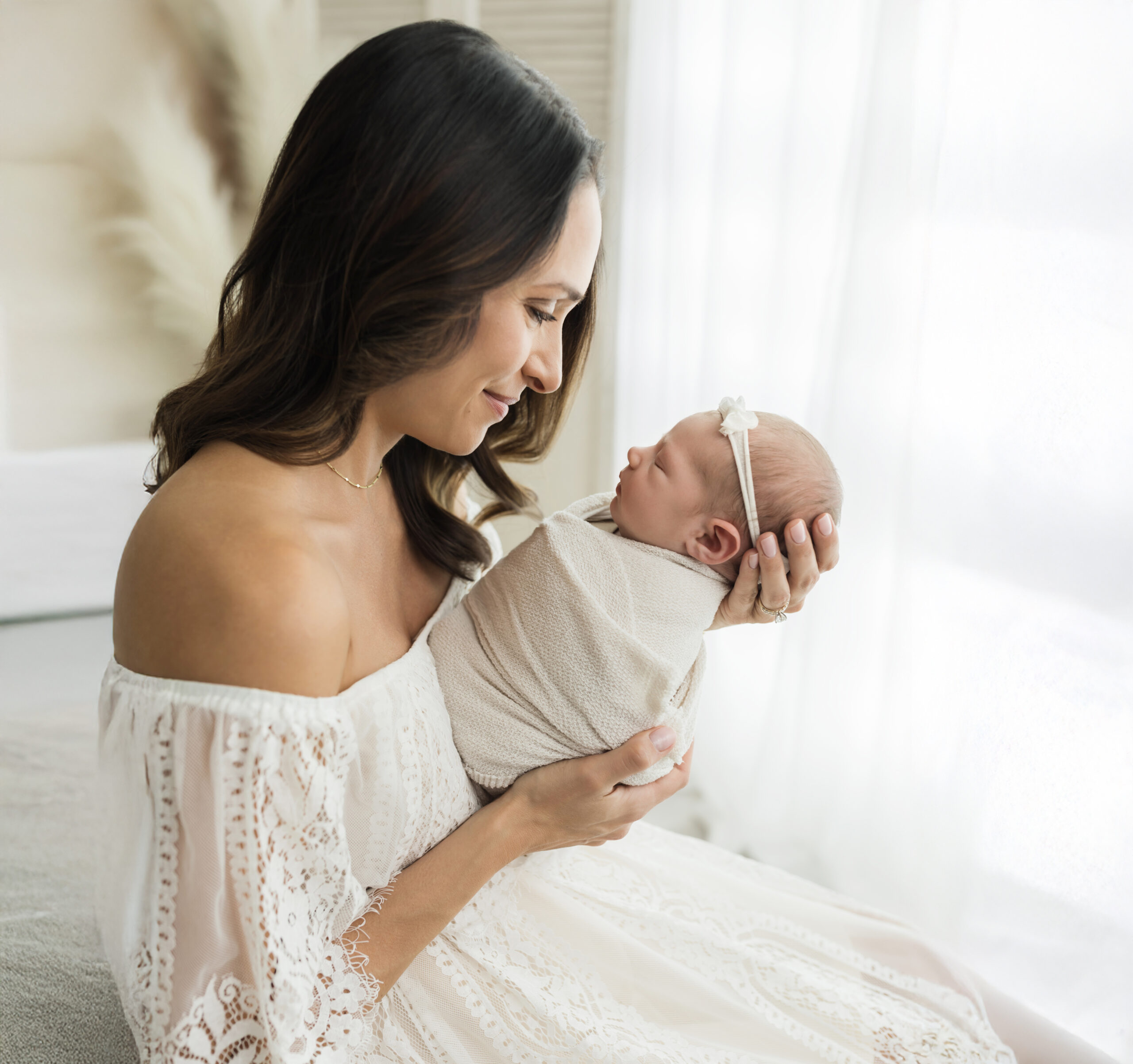 mom in white lace gown holding newborn baby girl Pelvic Floor Therapy Cleveland Clinic